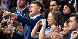 Tim Walz's son Gus (L) and daughter Hope (2nd L) react as he speaks during the DNC.